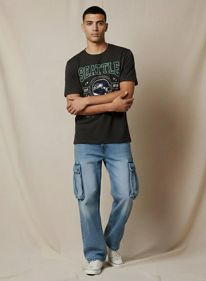 اس بي كاركترز تيشيرت رجالي مطبوع عليه شعار سياتل سيهوكس بياقة دائرية وأكمام قصيرة